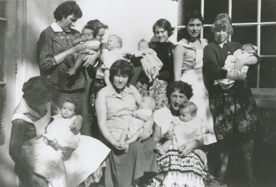 876984 Groepsportret van enkele (ongehuwde) moeders met hun baby's, op de binnenplaats van het opvanghuis 'Meisjesstad' ...